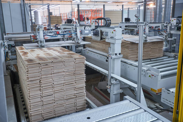 Carpentry factory. Automated equipment for laminate production. Modern robotic factory indoors. Woodworking production