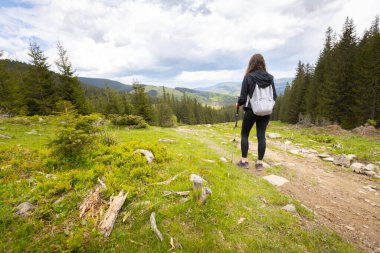 Woman hiker hiking in the mountains in summer to the highest ukrainian ridge Marmarosy near Romania.