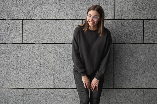 Woman wearing black sweatshirt or hoodie for mock up, logo designs or design prints with with free space on the city streets.