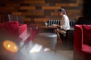 Bilgisayarlı bir iş kadını. Bir kafede çalışıyor ve latte içiyor.