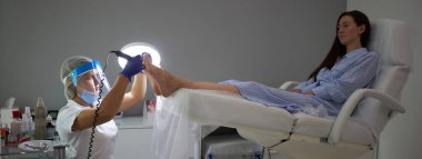 Güzellik salonunda pedikür SPA prosedürü uygulanıyor. Pedikür için elektrikli cihaz. Ayaklarını kaplıcaya sokan kadın.