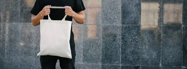 Νέος Άνθρωπος Που Κατέχει Λευκό Υφαντουργική Τσάντα Eco Κατά Του — Φωτογραφία Αρχείου