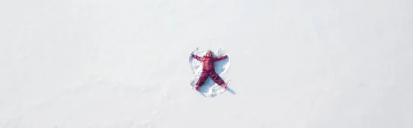小女孩在雪地里玩耍 做了个雪天使 顶部平坦的俯瞰 — 图库照片