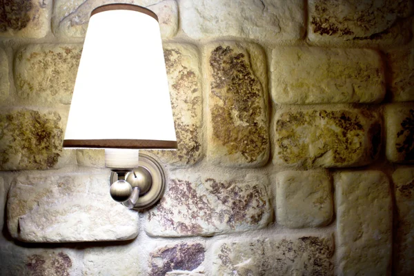 Lamp shining on a wall made of stones — Stock Photo, Image