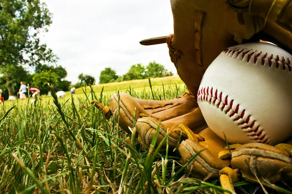 Baseball und alter Baseballhandschuh liegen auf dem E auf einem Baseballschläger — Stockfoto