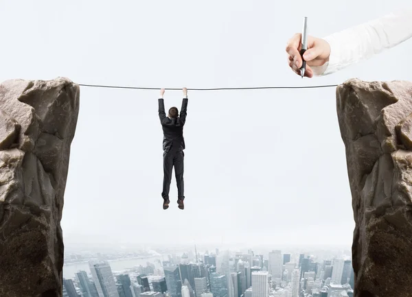 Businessman hanging on rope — Stock Photo, Image