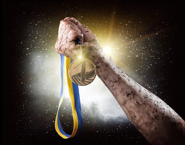 Mão com medalha sobre céu tempestuoso — Fotografia de Stock