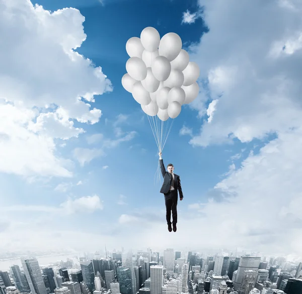 Businessman flying on balloons — Stock Photo, Image