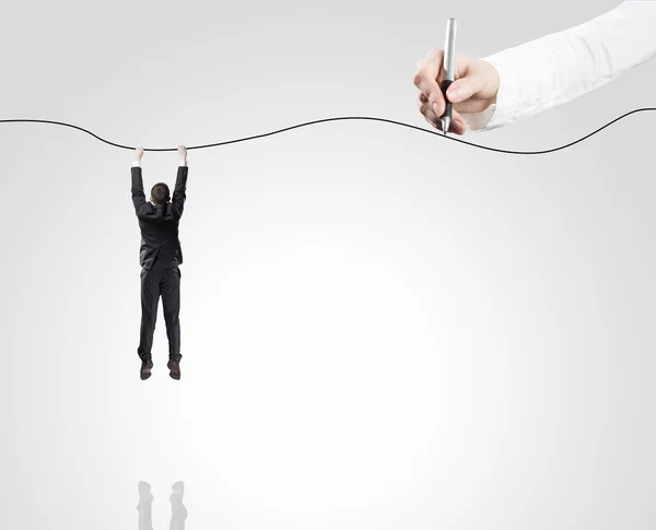 Businessman hanging on rope — Stock Photo, Image