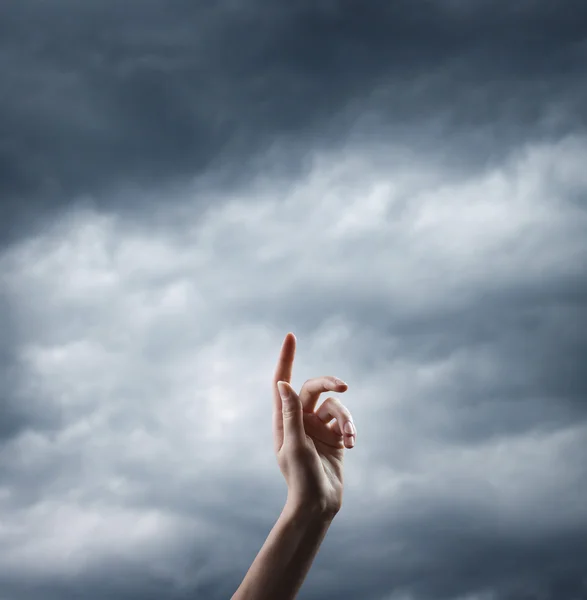 Hand over Cloudy stormy sky — Stock Photo, Image