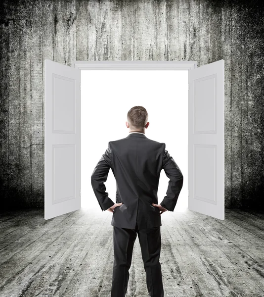 Businessman posing over doorway — Stock Photo, Image