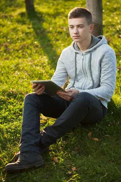 Jongen met tablet pc in het park — Stockfoto