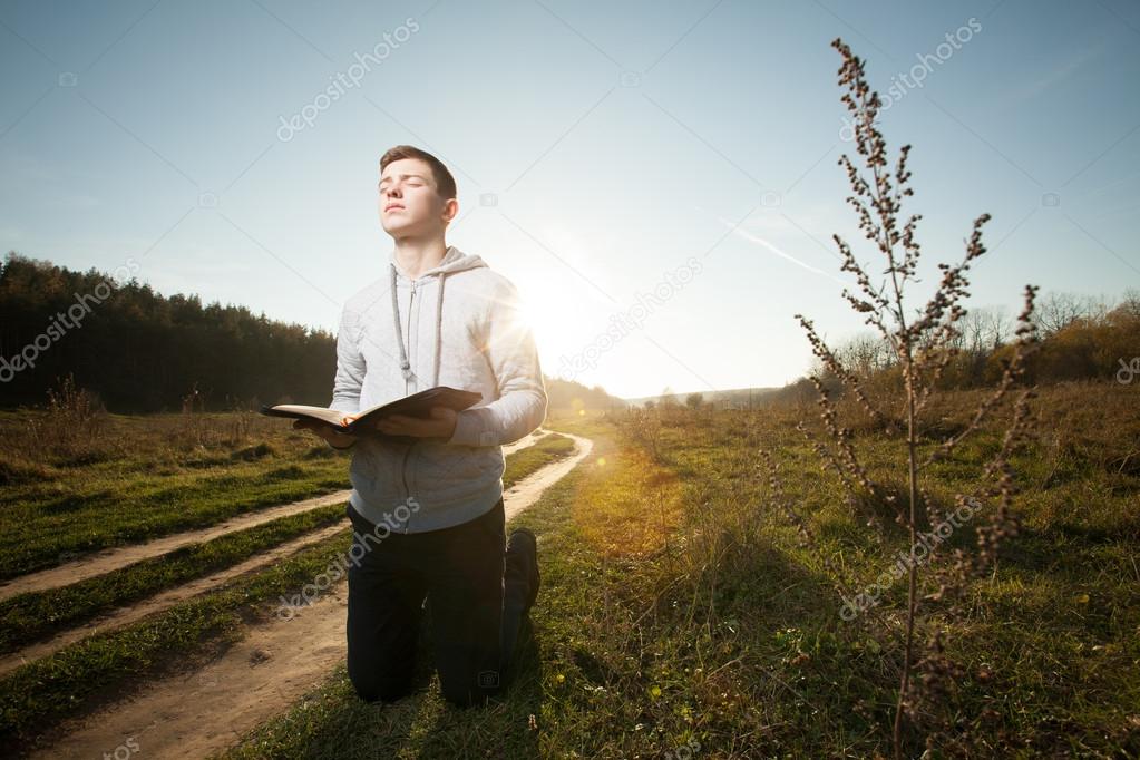 man reading Bible in park