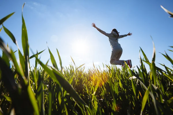 Vrouw springen op gras weide — Stockfoto