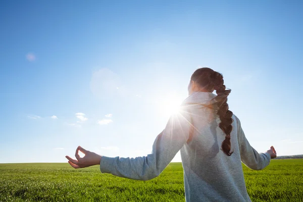 Mujer haciendo yoga en el campo de hierba — Foto de Stock