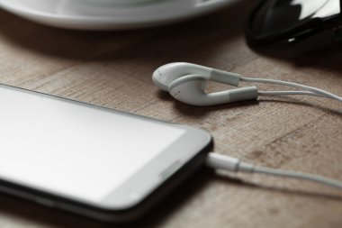 Kulaklık, telefon ve kahve fincan