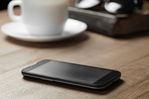 Téléphone intelligent sur la table en bois — Stockfoto