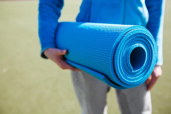 Femme marchant avec un tapis de yoga — Photo