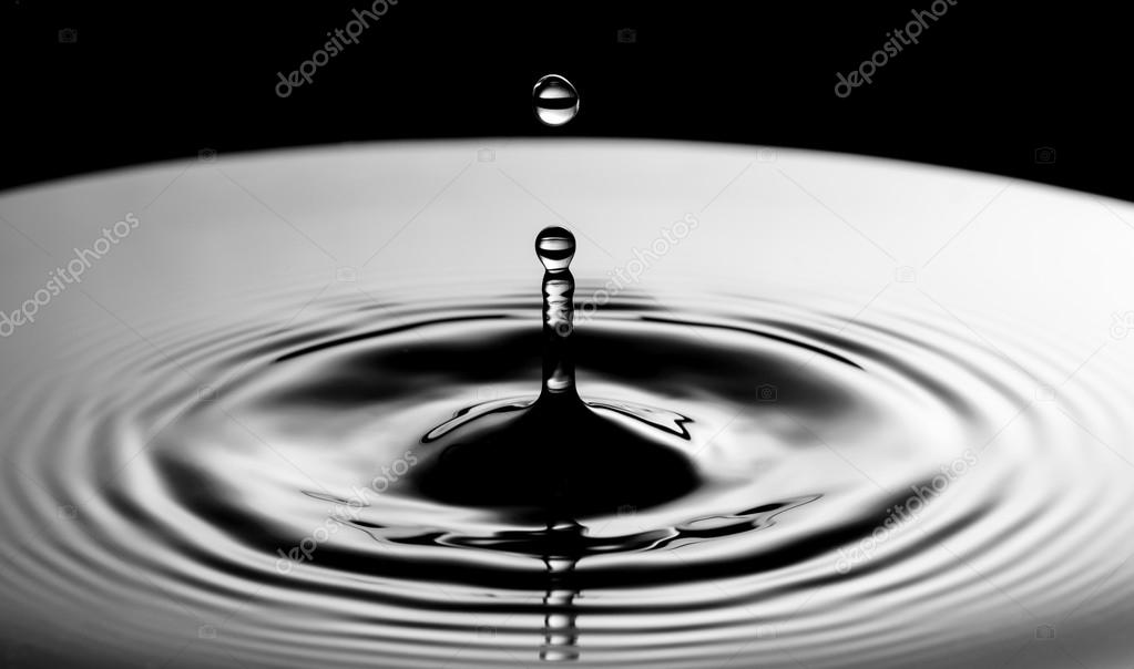 Water drop falling into water