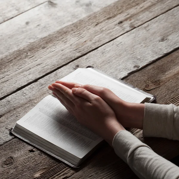 Manos de mujer rezando con una Biblia —  Fotos de Stock