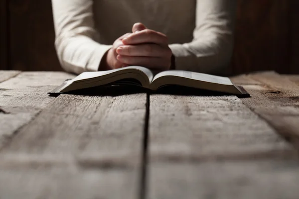 Manos de mujer rezando con una Biblia —  Fotos de Stock