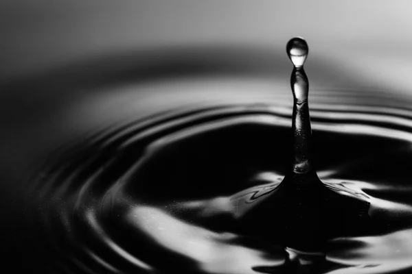 Stříkající vodě na černém pozadí. kapka vody — Stock fotografie