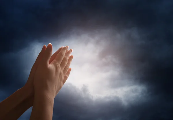 Mano alcanzando el cielo con nubes oscuras y tormentosas — Foto de Stock