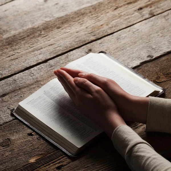 Ahşap arka plan üzerinde eller dua kadın — Stok fotoğraf