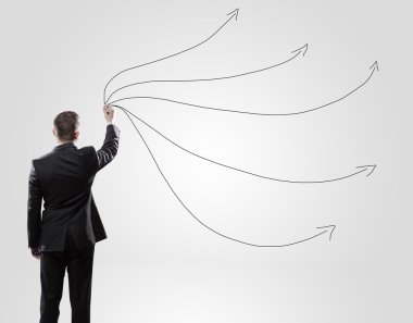 Back view of a businessman about to write something on a wall