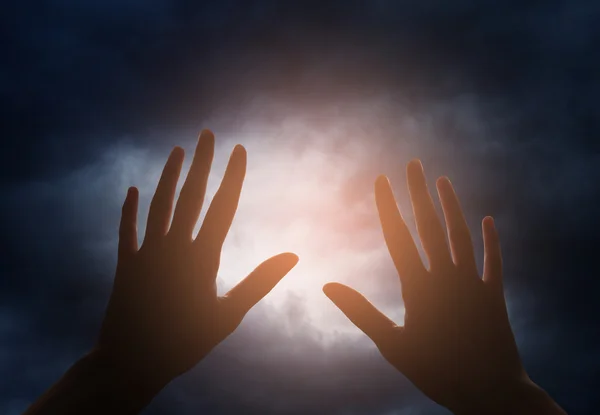 Mano alcanzando el cielo con nubes oscuras y tormentosas —  Fotos de Stock