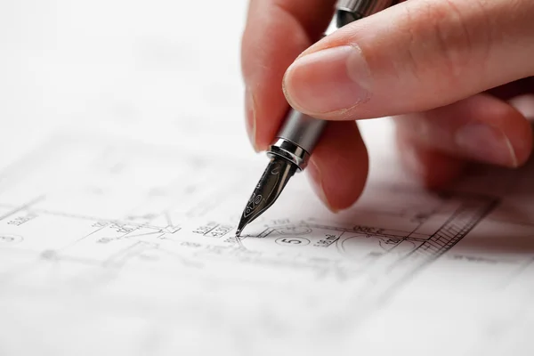 Vrouw met een pen over de blauwdruk van een huis — Stockfoto