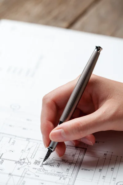 Vrouw met een pen over de blauwdruk van een huis — Stockfoto