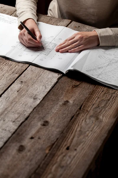 Donna che tiene una penna sopra un progetto di casa — Foto Stock