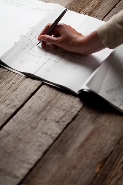 Frau hält Stift über Bauplan eines Hauses — Stockfoto