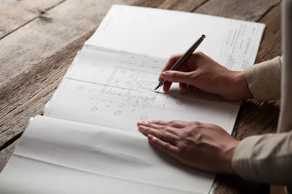 Vrouw met een pen over de blauwdruk van een huis — Stockfoto