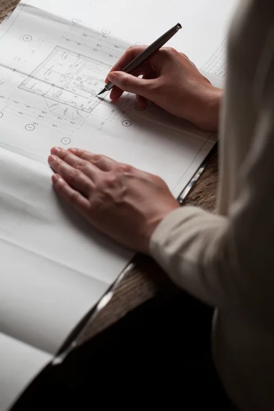 Vrouw met een pen over de blauwdruk van een huis — Stockfoto