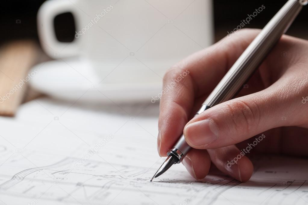 woman holding a pen over a house blueprint