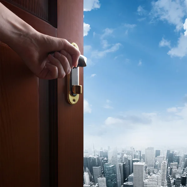 Hand opens door to the city downtown — Stock Photo, Image
