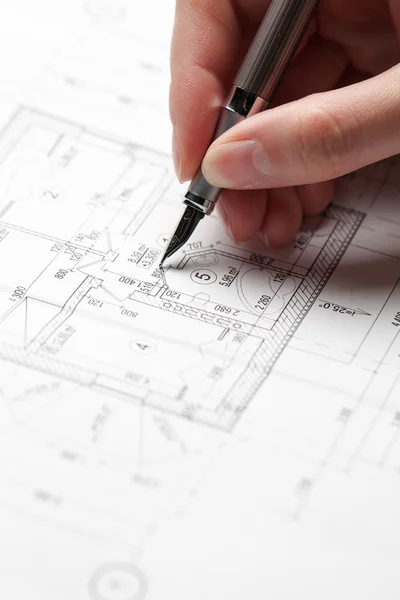 Woman holding a pen over a house blueprint — Stock Photo, Image