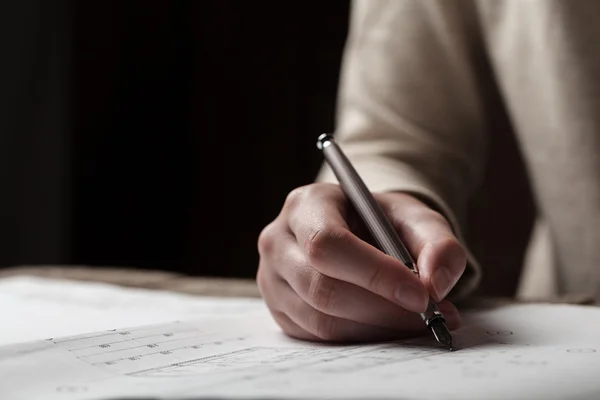 Woman holding a pen over a house blueprint — Stock Photo, Image