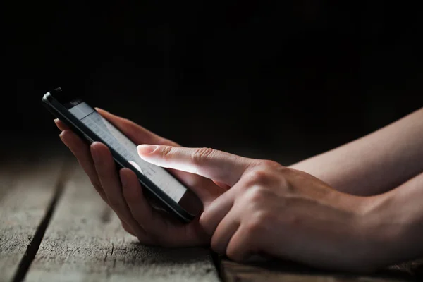 Mock up van slimme telefoon en meisje het bedrijf over een houten tafel — Stockfoto