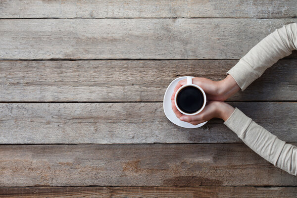 Woman hands holding mug of hot coffe