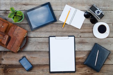 Boş kağıt üzerinde ipad stil tablet pc ve smartphone ile ahşap masa