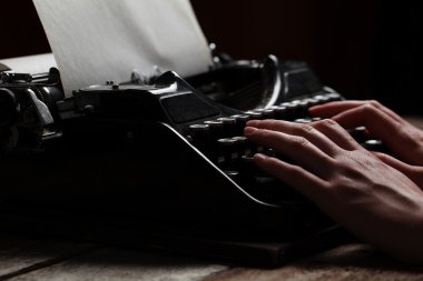 Ahşap masa arka plan üzerinde eski daktiloda yazı eller