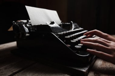 Ahşap masa arka plan üzerinde eski daktiloda yazı eller