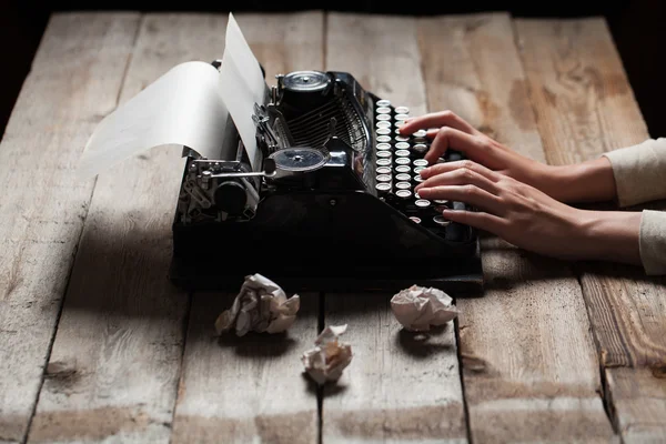Mãos escrevendo em máquina de escrever velha sobre fundo de mesa de madeira — Fotografia de Stock