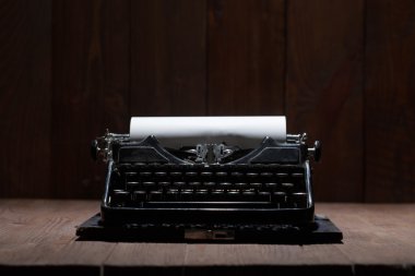 Typewriter over wooden background clipart