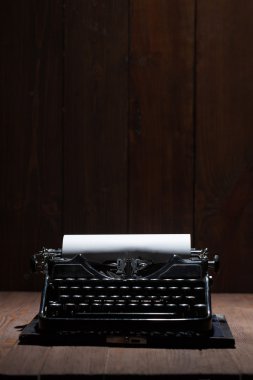 Old typewriter on a wooden table clipart