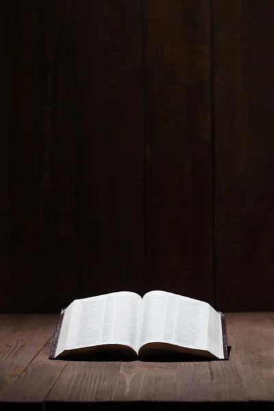 Imagen de una Santa Biblia sobre fondo de madera en un espacio oscuro — Foto de Stock