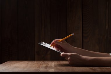 kadın eli kağıda ahşap masa üzerinde yazı